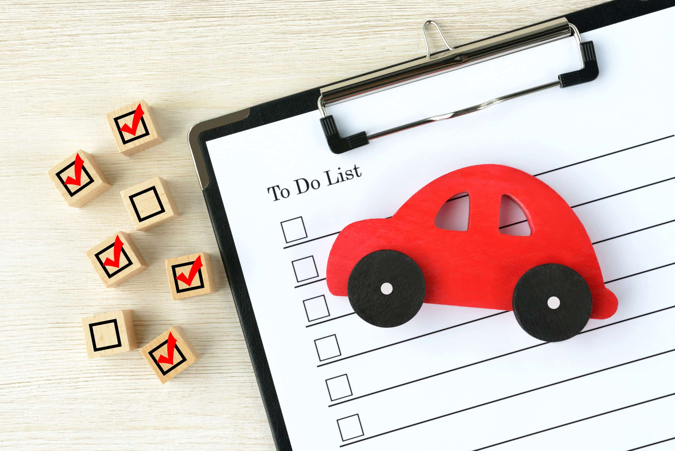 Clipboard to-do list with checkbox blocks and a red toy car