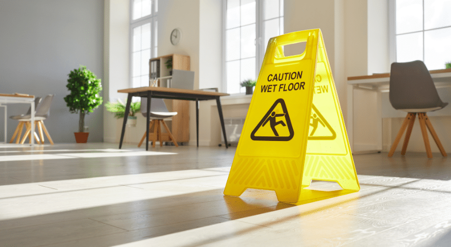 Yellow wet floor caution sign in a bright office space