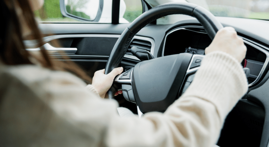 Driver's hands gripping the steering wheel