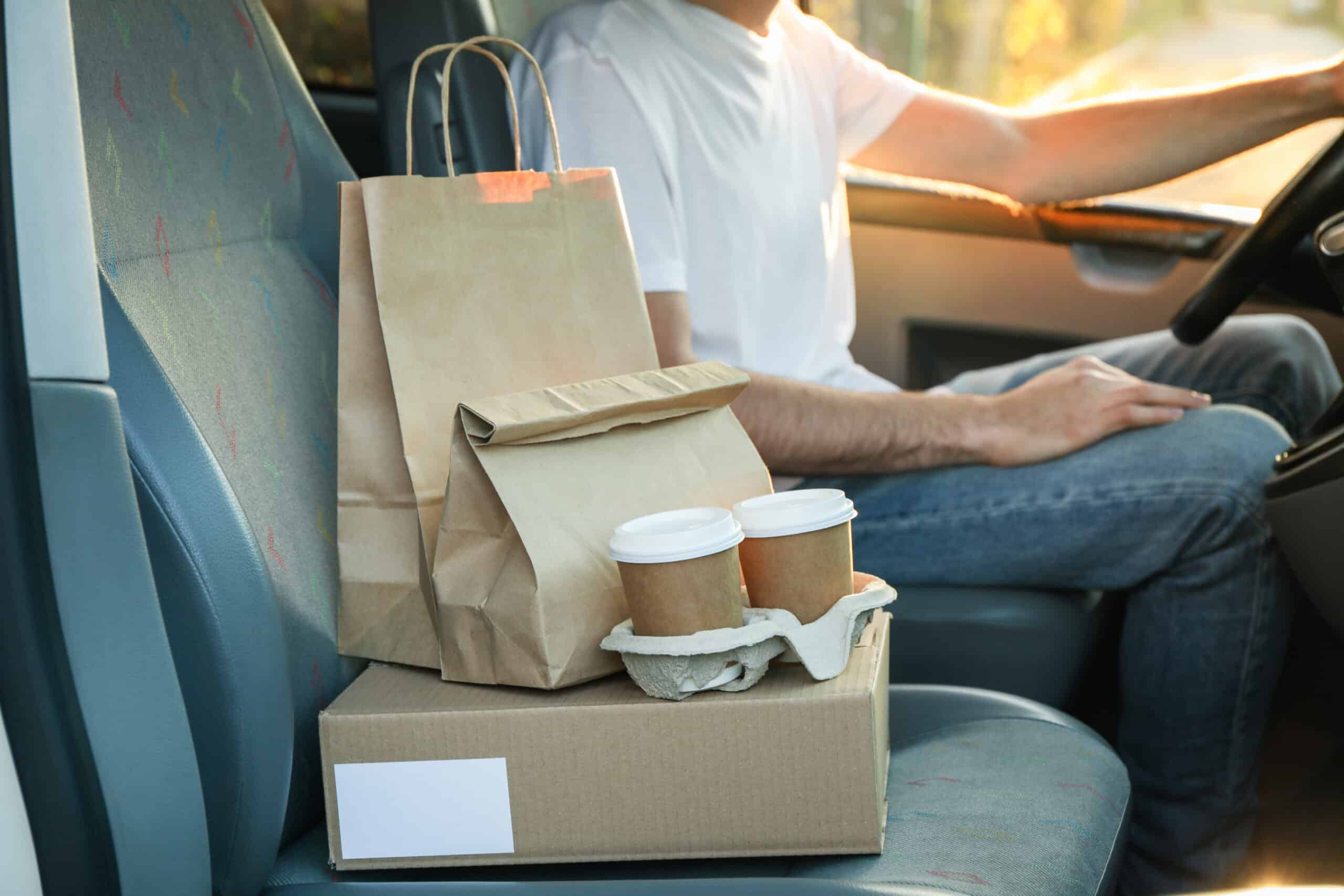 Food delivery bags and boxes on the passenger seat of a car