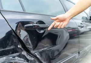man pointing out the damage from a car accident