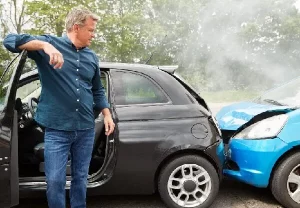 man observing damage following a car accident