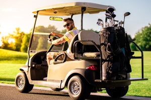 A man drives a golf cart in a neighborhood.