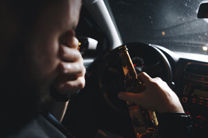 A drunk driver at the wheel of a car.