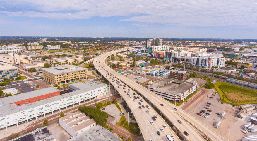 Aerial view of a busy multi-lane highway interchange through a city