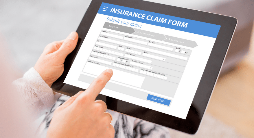 Hands using a tablet to fill out an insurance claim form