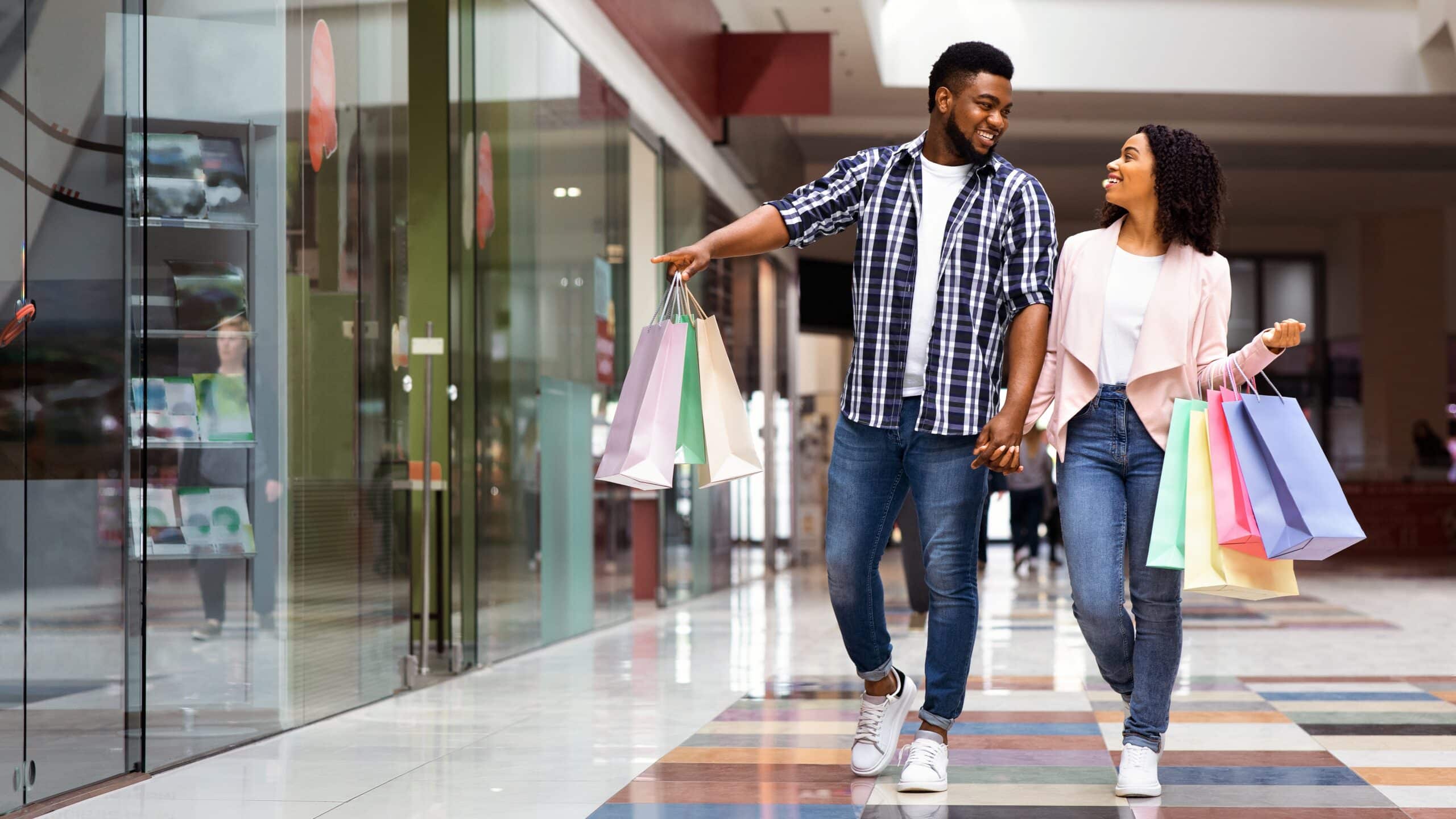Couple leaving a retail store carrying shopping bags