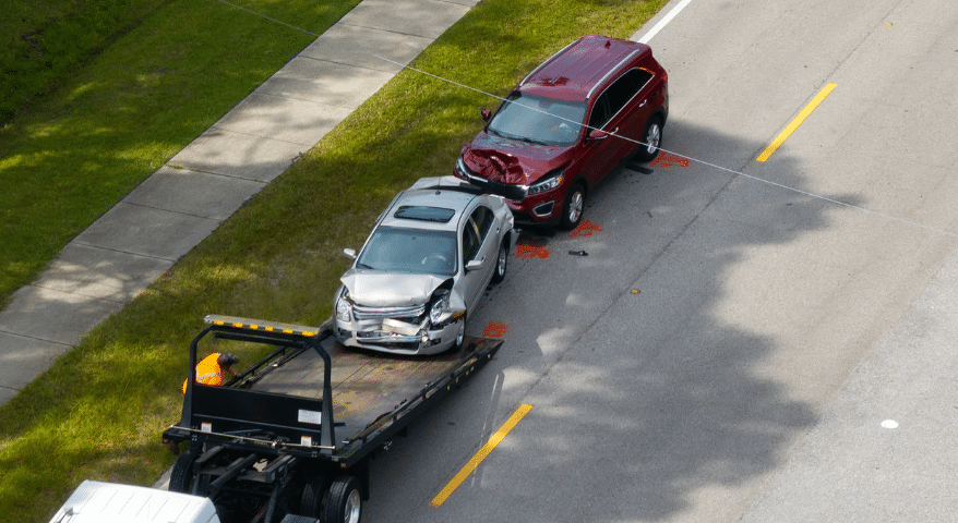 Aerial view of a damaged car being loaded onto a tow truck