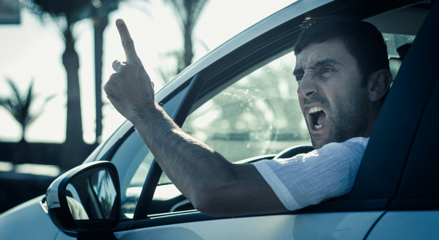 Angry driver shouting and gesturing out of a car window