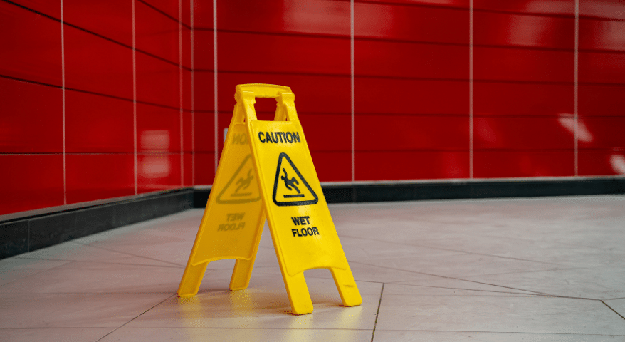 Yellow wet floor caution sign in a tiled hallway