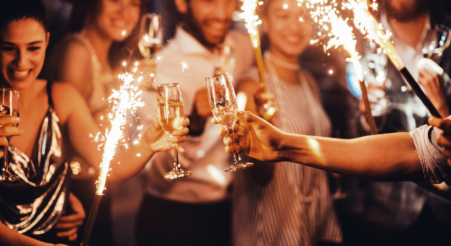 Group of friends toasting champagne with sparklers at a party