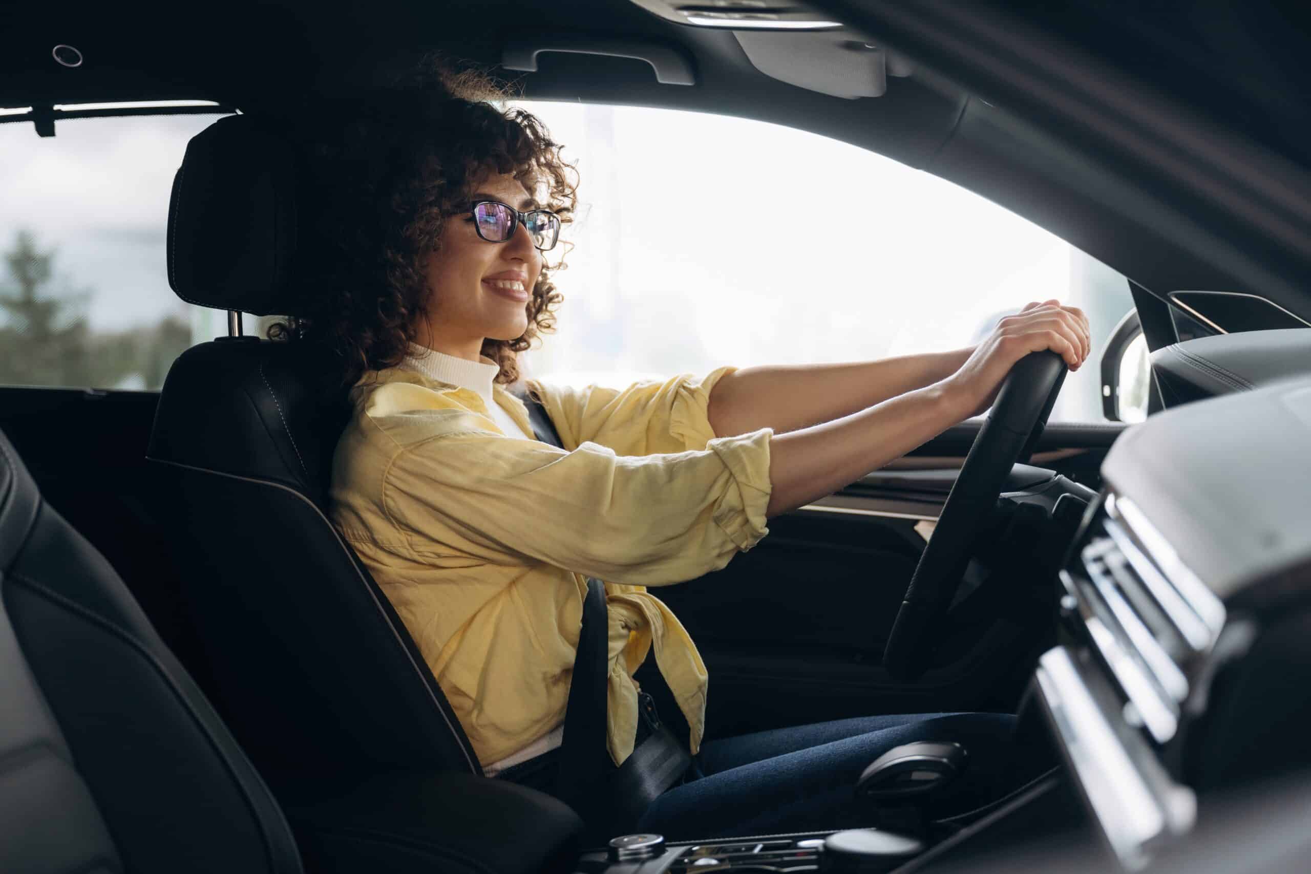 Woman driving a car with her hands on the steering wheel