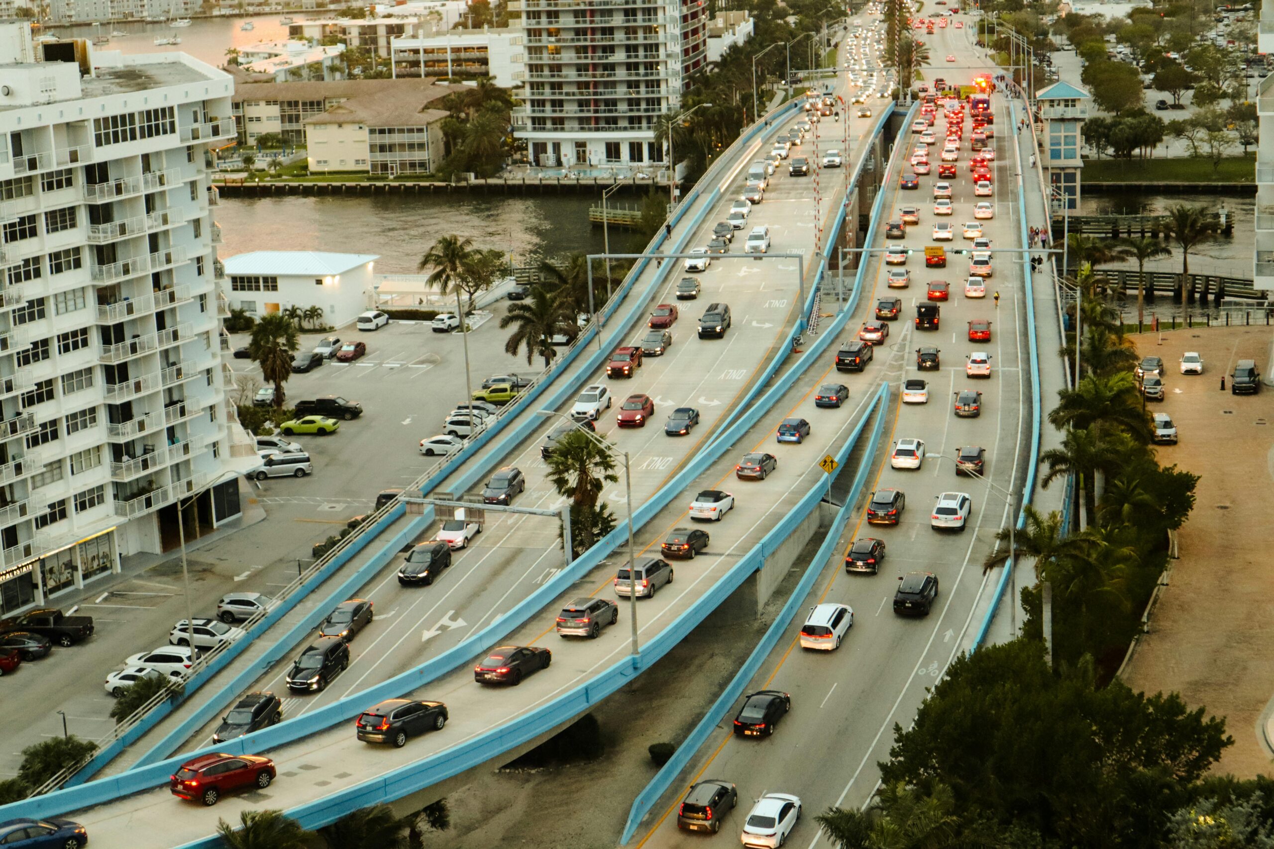 Aerial view of a busy multi-lane bridge and highway interchange in a Florida coastal city.