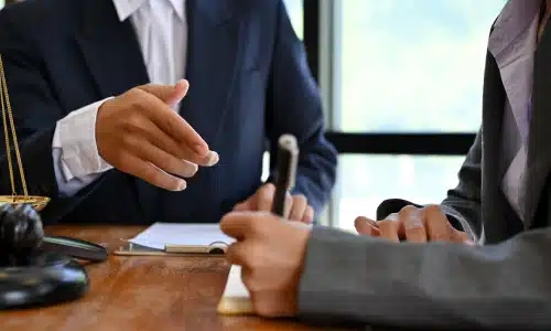 A personal injury lawyer at a desk together with a client working on documents for a claim.