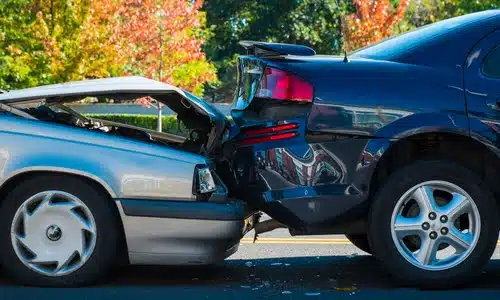 A serious rear-end accident between two cars resulting in damage to both vehicles.