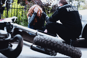 A man is thinking about hiring a motorcycle accident lawyer after a crash. 