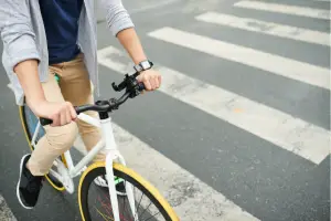 A cyclist on a busy street in the middle of an intersection.