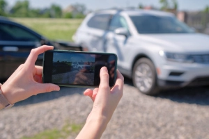 An accident victim taking a photo of a car accident for documentation for her claim.