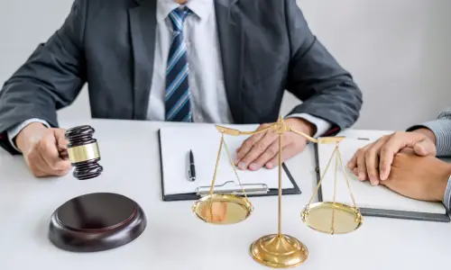 A boating accident lawyer serving Carrollwood has his hand on a document while he talks to a client sitting at his left side