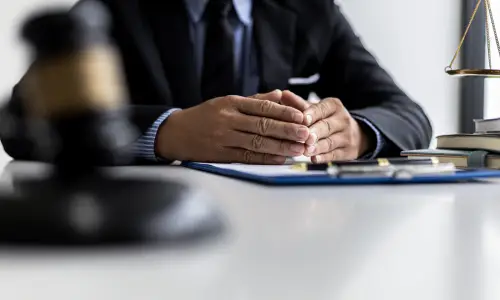 A Carrollwood drunk driving accident lawyer sits with hands together on top of an office desk