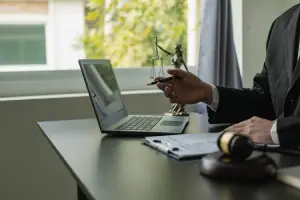 A Lyft accident lawyer serving Carrollwood is on an online meeting on his office laptop while gesturing with his hands