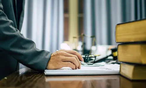 A Carrollwood pedestrian accident lawyer stands while reading a book on top of an office desk