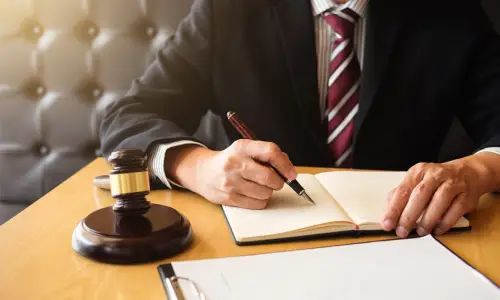 A premises liability lawyer writes on a notebook while he sits in a Carrollwood law office