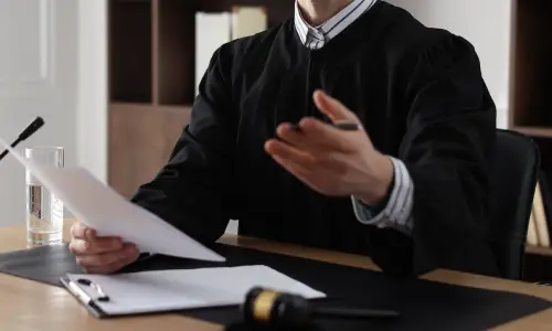 A traumatic brain injury lawyer gestures while explaining the contents of a document in his hands as he sits in a Carrollwood law office