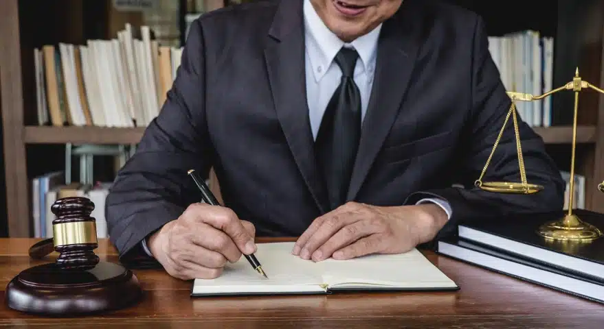 A slip and fall lawyer serving Florida writing on an open notebook with bookshelves in the background