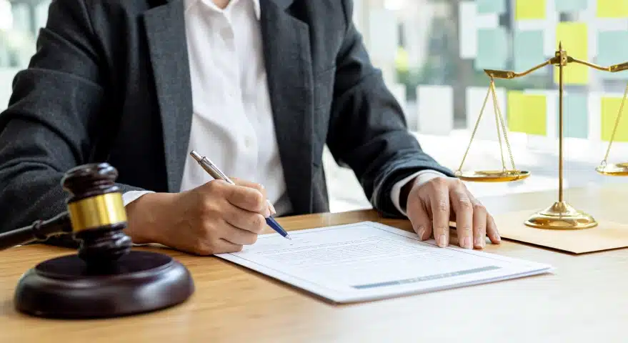 A slip and fall lawyer serving florida signing legal documents on a clipboard placed on an office desk