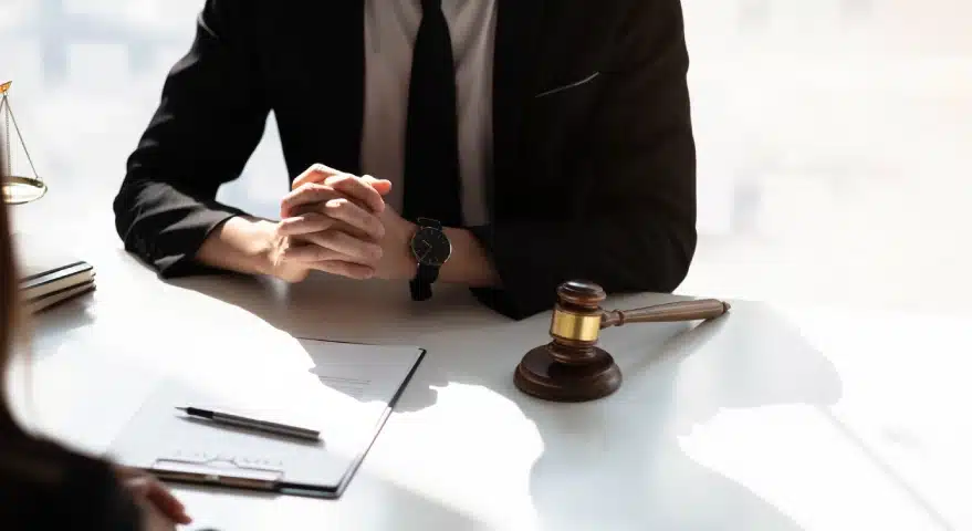 A Florida slip and fall lawyer speaks with a client sitting across an office desk with a contract on top