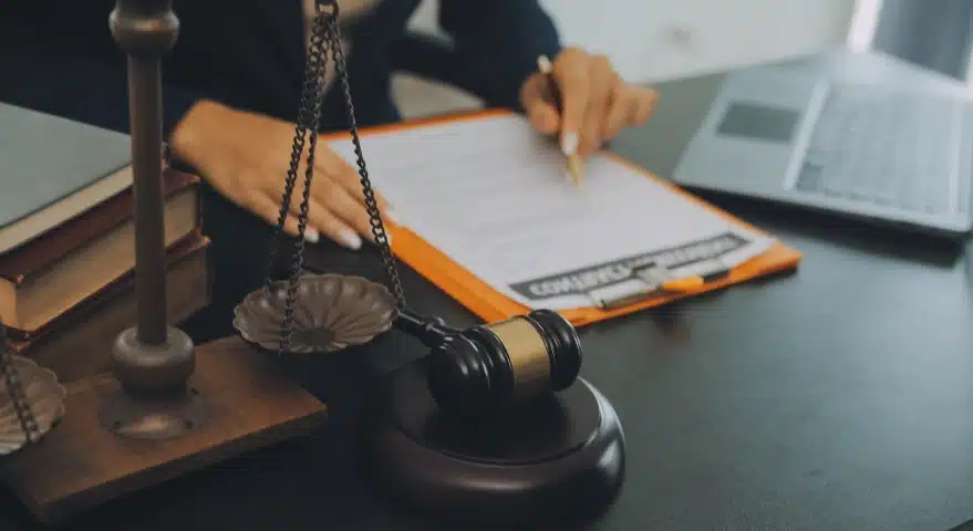 A Florida slip and fall lawyer signing documents on an orange clipboard placed on the office desk