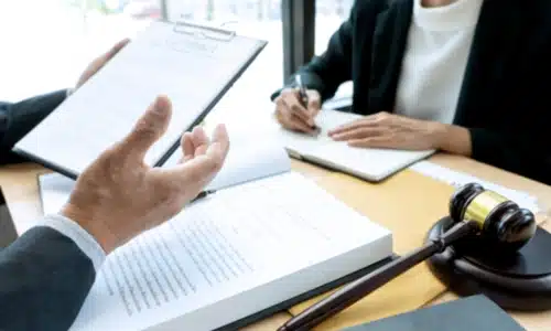 A Riverview motorcycle accident lawyer reading legal documents while a colleague takes down important notes on the other end of the table