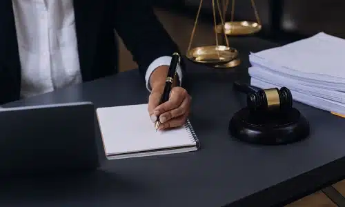 A Riverview negligent security lawyer writing down notes in a notebook in preparation for a client's case.