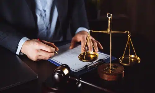 A Riverview pedestrian accident lawyer filling out forms for a client's personal injury claim at his office desk.