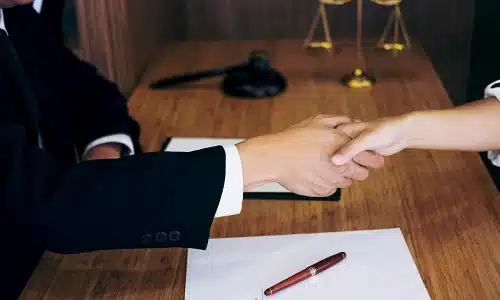 A Riverview swimming pool accident lawyer shaking hands with a client in an office when they meet to discuss a case.