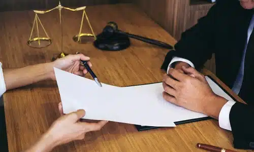 A Riverview traumatic brain injury lawyer is letting aclient sign a contract whule they sit inside a law office