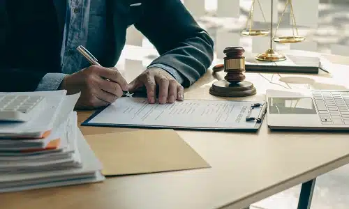 A Riverview workers' compensation lawyer with papers and books on his desk working on a client's personal injury claim.