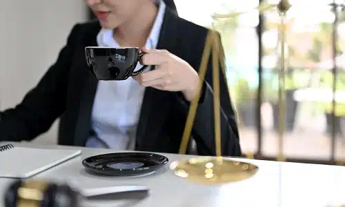 A Tampa birth injury lawyer reading through legal documents while holding up a cup of coffee