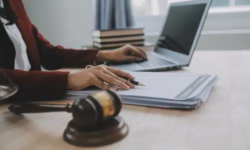 A Tampa car accident lawyer compares notes on a laptop to documents lying on an office desk