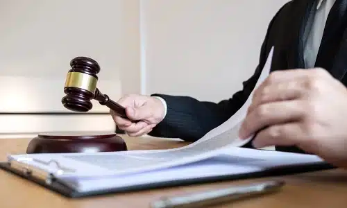 A Tampa distracted driving accident lawyer reads through case files attached to a clipboard on a table