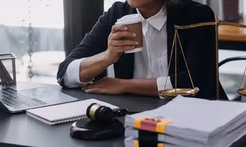 A left turn accident lawyer working on an office desk while drinking a cup of coffee