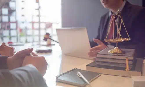 A Tampa motorcycle accident lawyer discusses a case on a laptop with colleagues sitting across a table