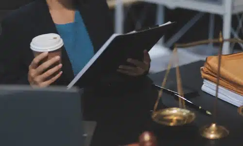 A Tampa slipa and fall lawyer reviewing case files and carrying a cup of coffee