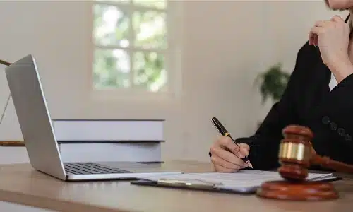 A Florida car accident lawyer signing a legal document while working on a laptop