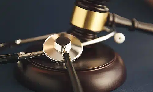 A photo of a gavel and a stethoscope on a table.
